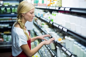 Staff checking grocery products in shelf of supermarket as part of predictive maintenance routine