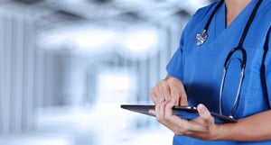 Nurse using personal digital assistant in healthcare environment